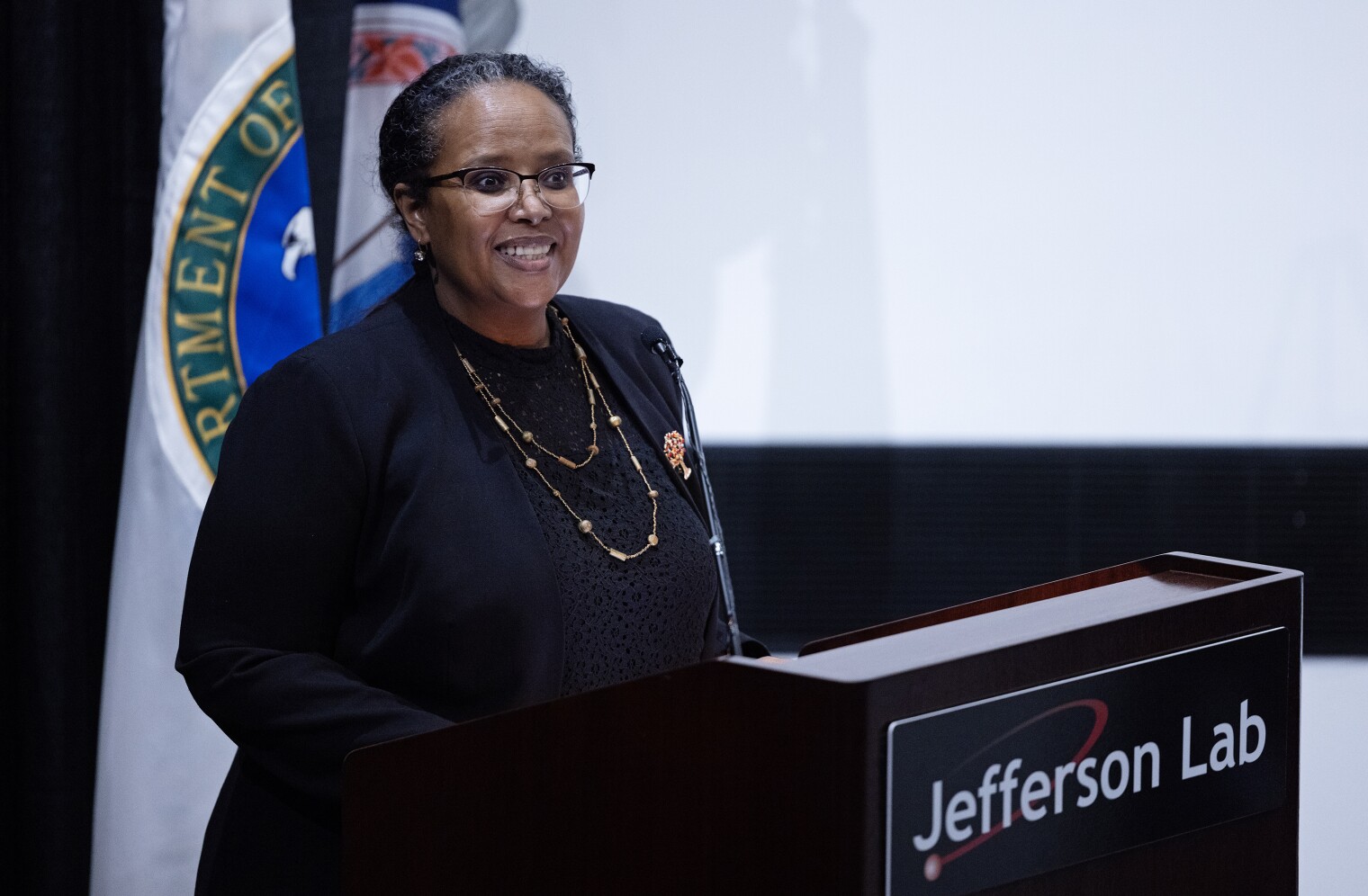 DOE Office of Science Director Asmeret Asefaw Berhe standing at a podium at Jefferson Lab.