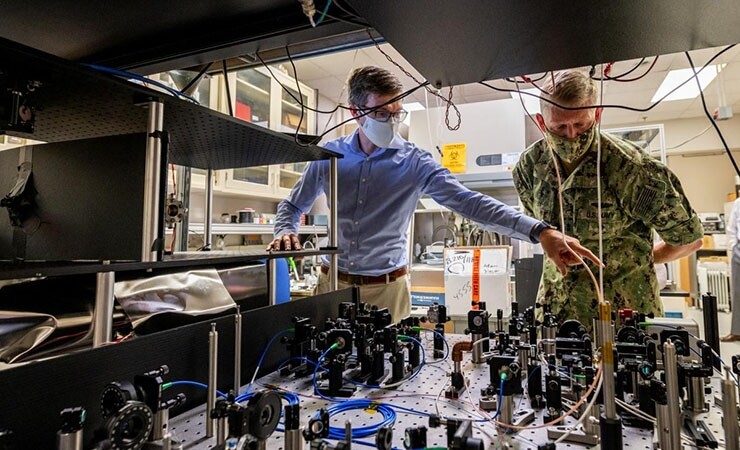 Chief of Naval Research Rear Adm. Lorin Selby, right, views an atom interferometer at the Naval Research Laboratory.  (Image credit - Jonathan Steffen / U.S. Navy)