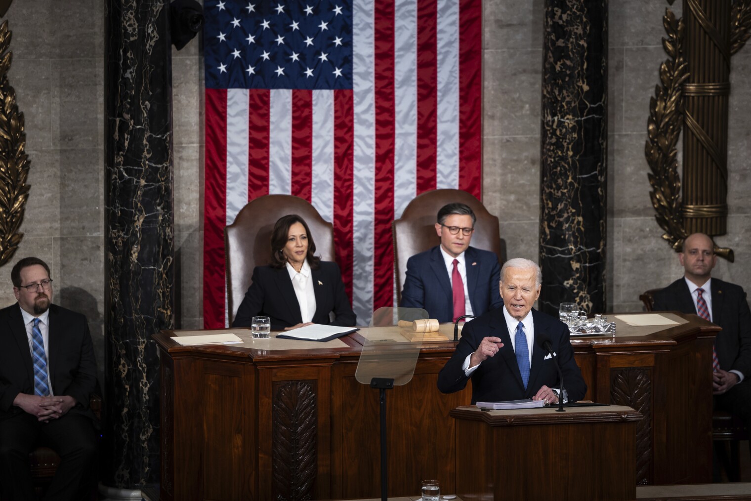 President Joe Biden delivers the State of the Union address to a joint session of Congress at the Capitol, Thursday, March 7, 2024, in Washington. Standing at left is Vice President Kamala Harris and seated at right is House Speaker Mike Johnson, R-La.