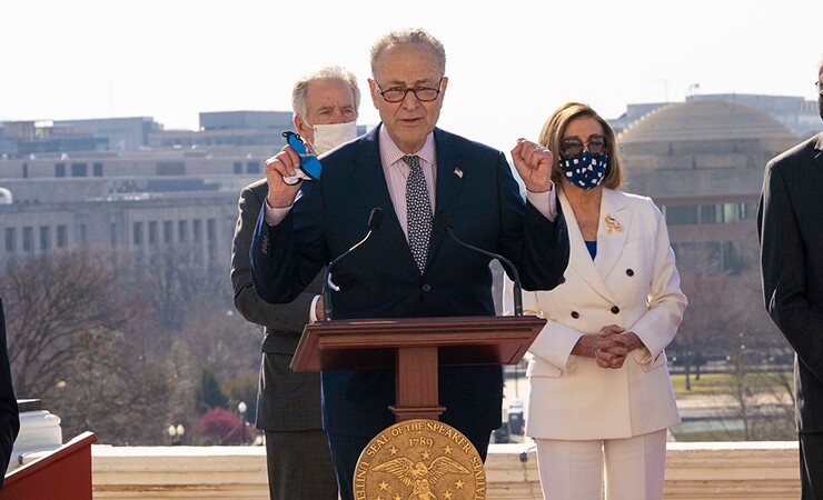 Accompanied by House Speaker Nancy Pelosi (D-CA) and other lawmakers, Senate Majority Leader Chuck Schumer (D-NY) celebrates the passage of the American Rescue Plan Act, a $1.9 trillion pandemic relief bill. 