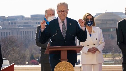 Accompanied by House Speaker Nancy Pelosi (D-CA) and other lawmakers, Senate Majority Leader Chuck Schumer (D-NY) celebrates the passage of the American Rescue Plan Act, a $1.9 trillion pandemic relief bill. 