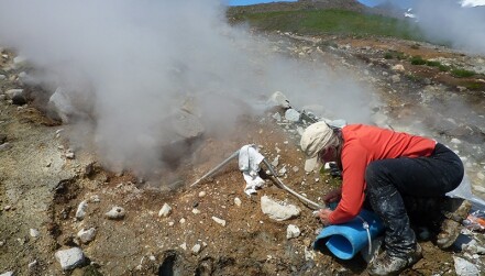 A USGS scientist collects a gas sample on the flank of Akutan Volcano in Alaska