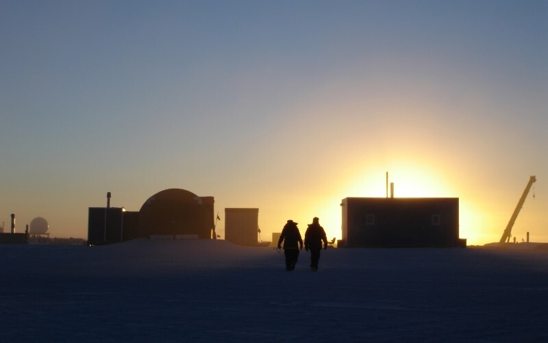 Two figures in silhouette during sunset in Antarctica